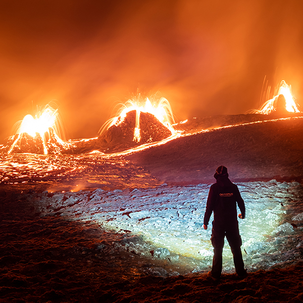 Man with a very bright flashlight infront of three volcanos Man with a very bright flashlight infront of three volcanos