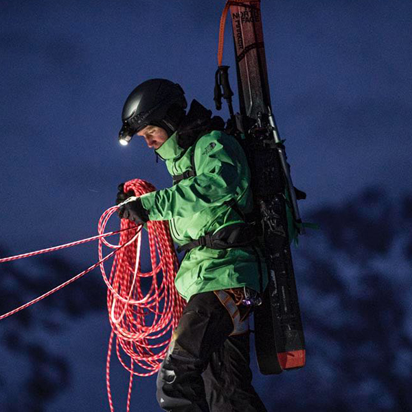 Outdoor-Stirnlampe von Ledlenser Das Bild zeigt einen Mann mit Outdoor-Stirnlampe, die an einem Helm befestigt ist