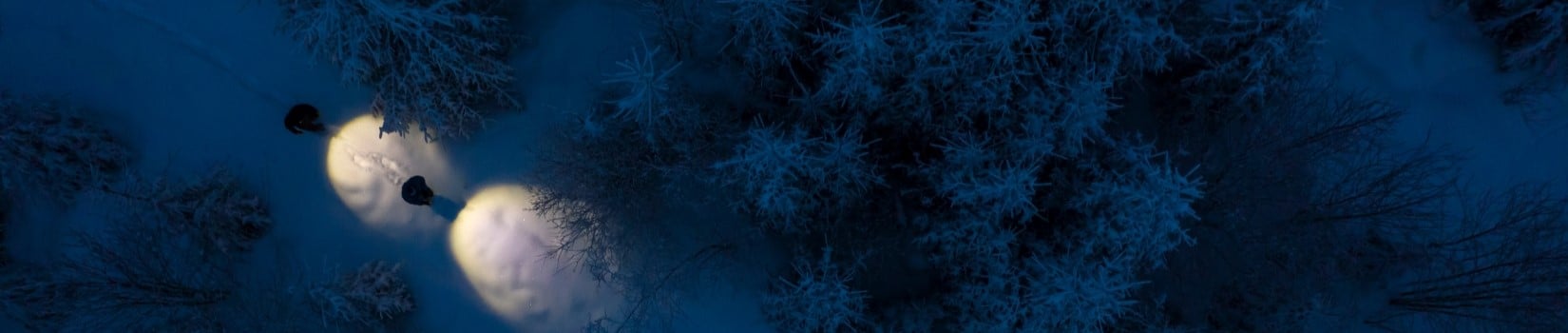 Two people doing a night hike in winter