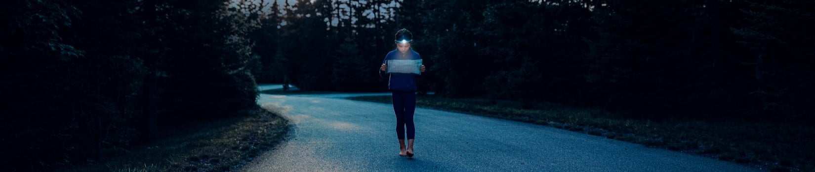 A girl does a night hike with a headlamp