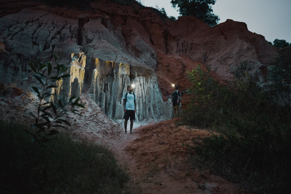 Two people with headlamps in the mountains
