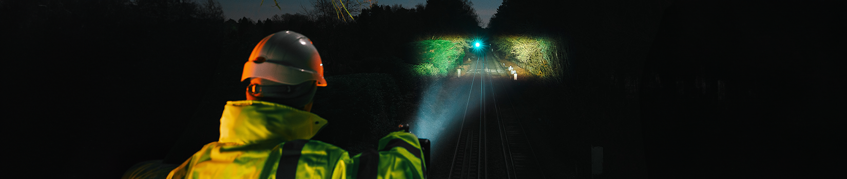 Das Bild zeigt einen Bahnmitarbeiter mit Taschenlampe
