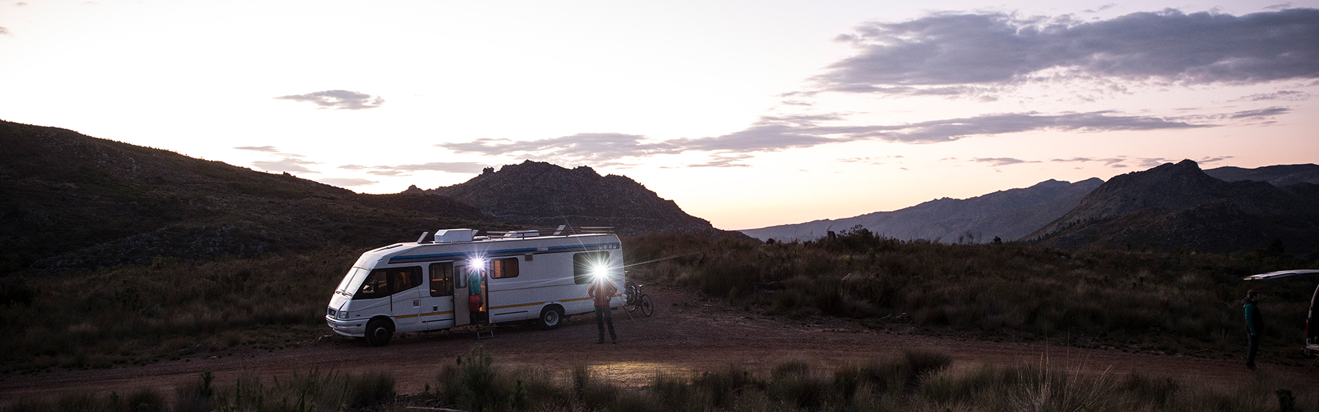 Two people with headlamps standing in front of a trailor
