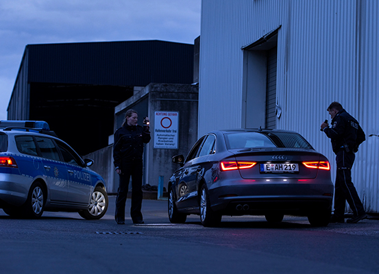A a police woman and a police man with a flashlight