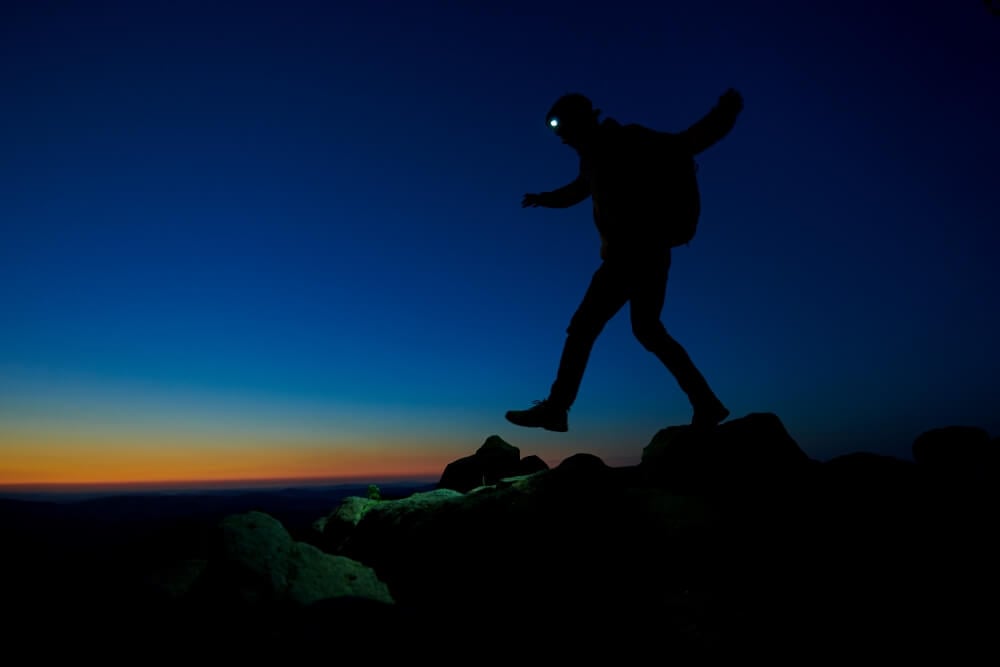 Man is doing a night hike with a headlamp