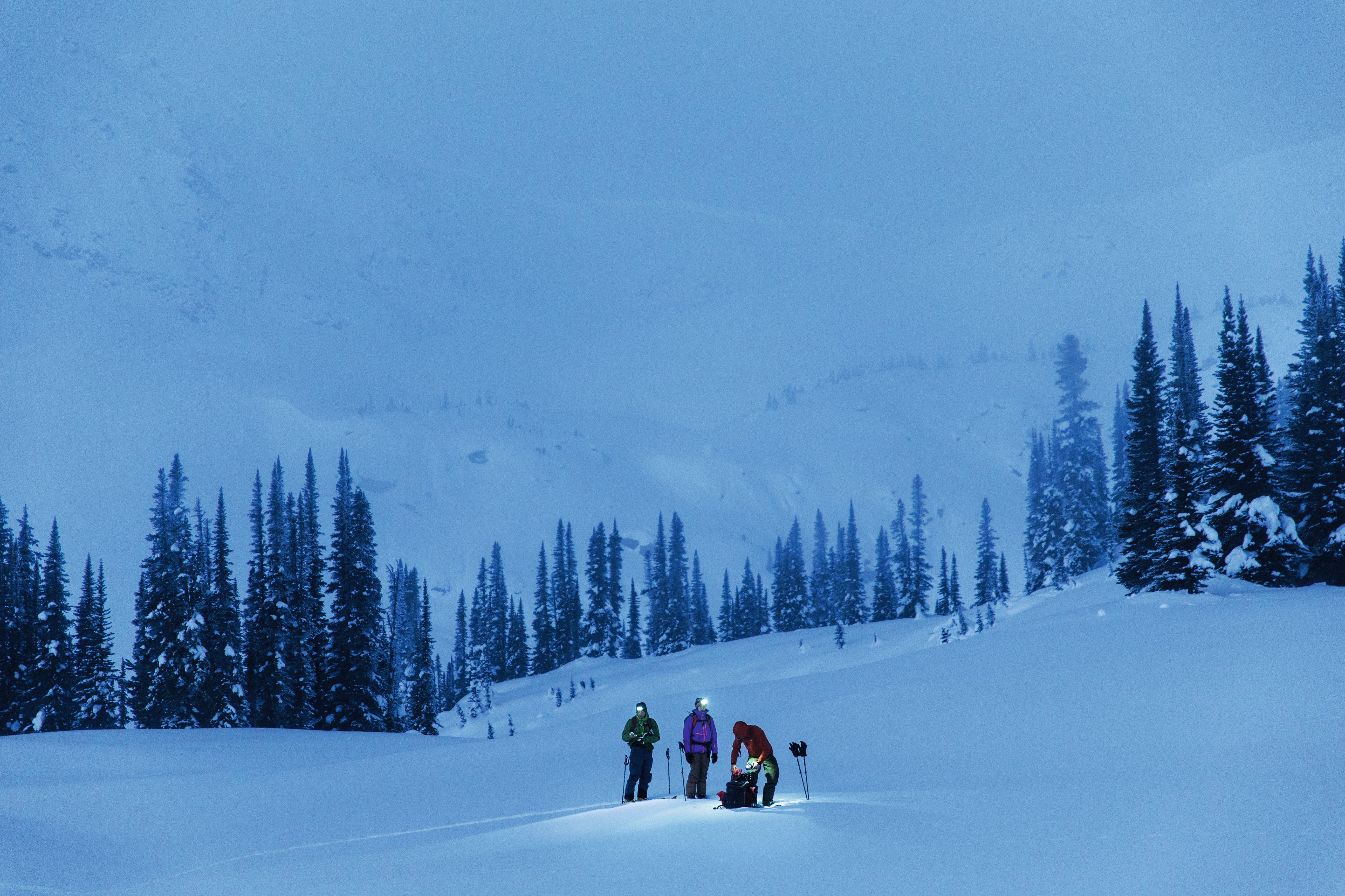 People in the snow using headlamps