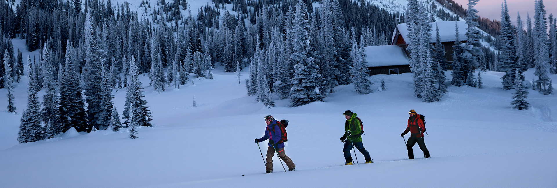 Drei Personen machen eine Skitour mit Stirnlampen